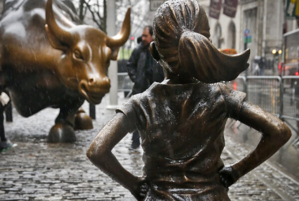 New York's Mandatory Retirement Landscape: Fearless Girl statue defiantly faces off against Wall Street Bull, symbolizing strength and resilience in the financial world.